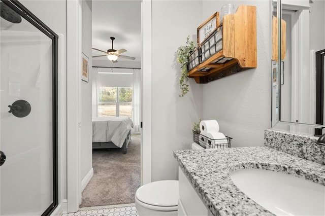 bathroom featuring a shower with door, vanity, ceiling fan, and toilet