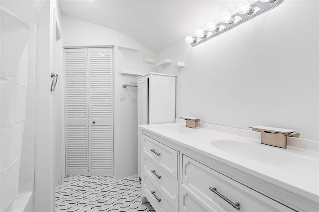 bathroom with vanity, vaulted ceiling, and tile patterned flooring