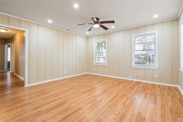 spare room featuring ornamental molding, light wood-type flooring, and ceiling fan