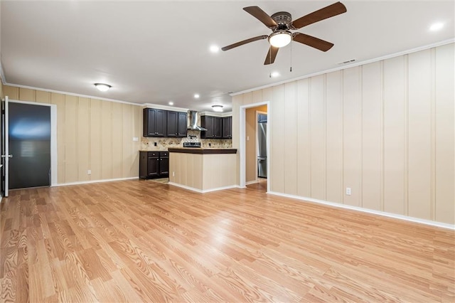 unfurnished living room featuring ceiling fan, ornamental molding, and light hardwood / wood-style flooring