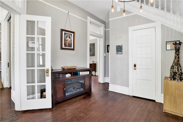 foyer featuring dark wood-type flooring, baseboards, and lofted ceiling