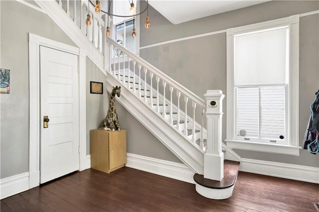staircase featuring plenty of natural light, hardwood / wood-style flooring, and baseboards