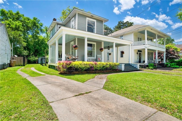 view of front of home featuring driveway, a porch, a front lawn, and a balcony