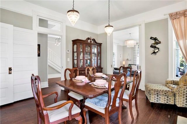 dining room featuring a chandelier, dark wood-type flooring, and stairway