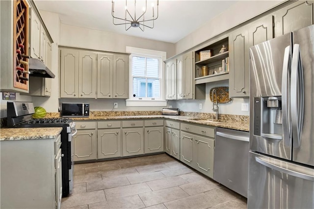 kitchen featuring a sink, appliances with stainless steel finishes, a chandelier, under cabinet range hood, and gray cabinets