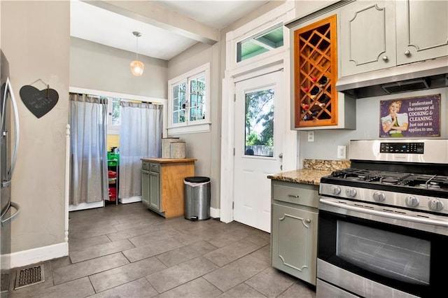 kitchen with baseboards, under cabinet range hood, a wealth of natural light, and stainless steel appliances