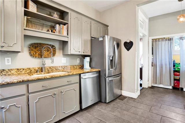 kitchen with baseboards, gray cabinets, open shelves, appliances with stainless steel finishes, and a sink