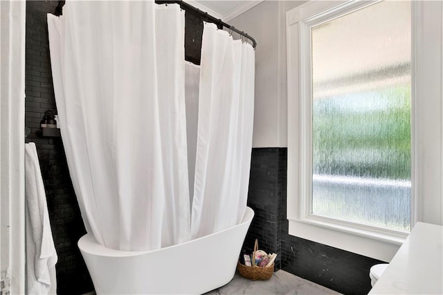 bathroom featuring crown molding, a freestanding tub, marble finish floor, and a shower with curtain