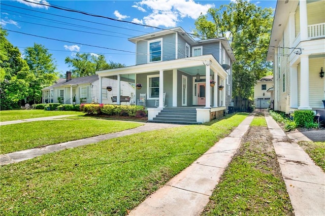 view of front of property featuring a porch, a front lawn, a gate, and concrete driveway