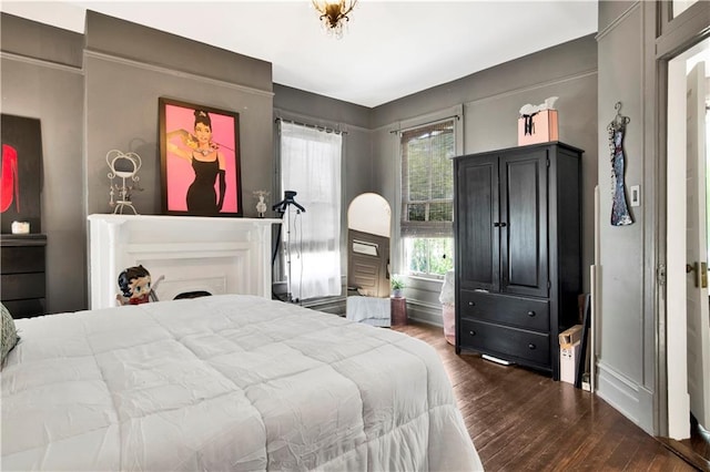 bedroom with dark wood-type flooring and baseboards