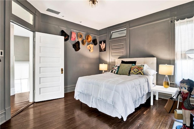 bedroom with dark wood-style flooring and visible vents