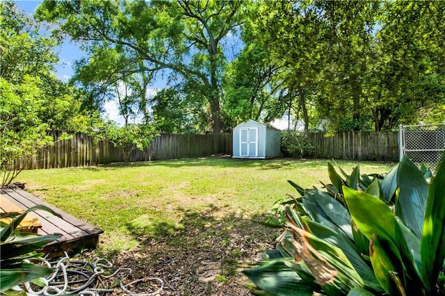 view of yard with a fenced backyard, an outdoor structure, and a shed