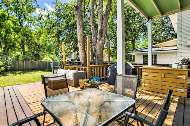 deck featuring outdoor dining space, outdoor lounge area, grilling area, a fenced backyard, and a lawn