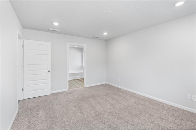 unfurnished bedroom with light carpet and ensuite bath