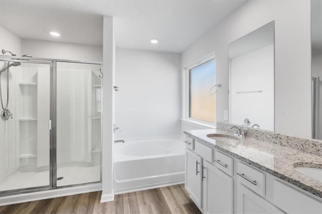 bathroom with shower with separate bathtub, wood-type flooring, and vanity