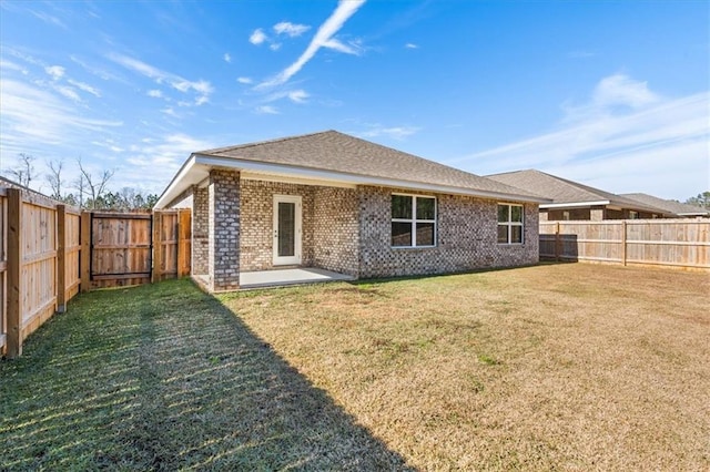 rear view of property featuring a yard and a patio area