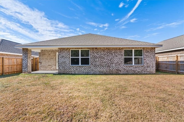 rear view of house featuring a yard and a patio