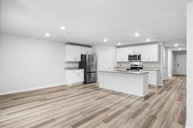 kitchen featuring light hardwood / wood-style floors, stainless steel appliances, an island with sink, white cabinets, and sink