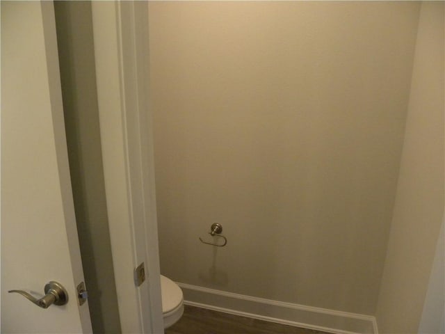 bathroom featuring hardwood / wood-style flooring and toilet