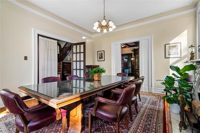 dining area with hardwood / wood-style floors, ornamental molding, and an inviting chandelier