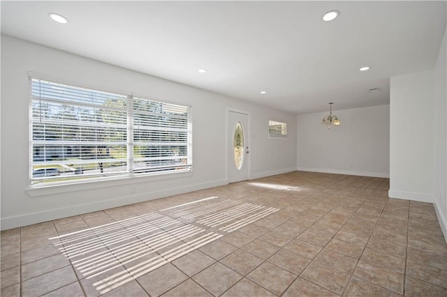 tiled entrance foyer with a notable chandelier