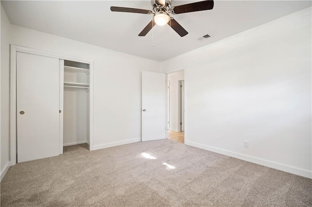 unfurnished bedroom with light carpet, a closet, and ceiling fan