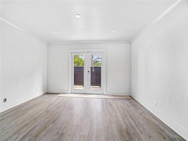 spare room featuring crown molding, wood-type flooring, and french doors