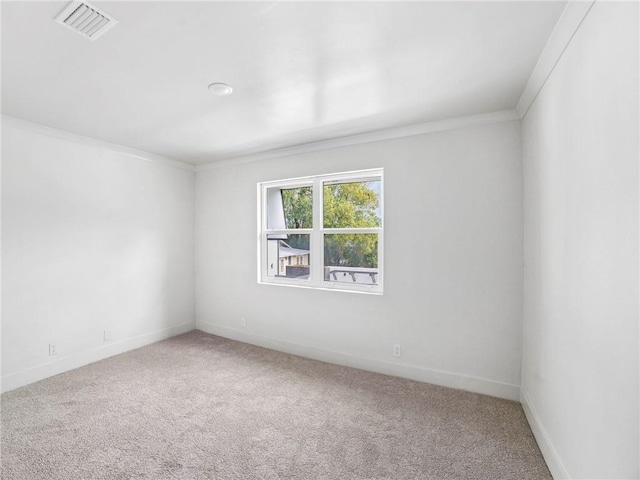 carpeted empty room featuring crown molding