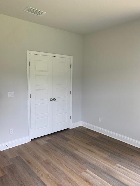 unfurnished bedroom featuring wood-type flooring and a closet