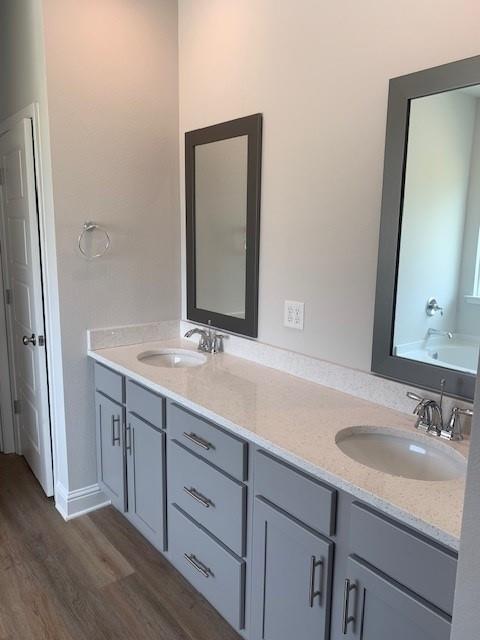 bathroom with hardwood / wood-style flooring, vanity, and a bathtub