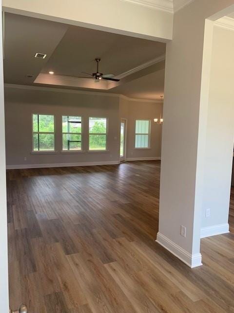 unfurnished room featuring crown molding, ceiling fan, a raised ceiling, and dark wood-type flooring