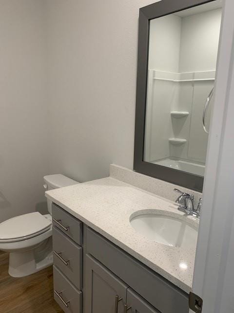 bathroom with hardwood / wood-style flooring, vanity, and toilet