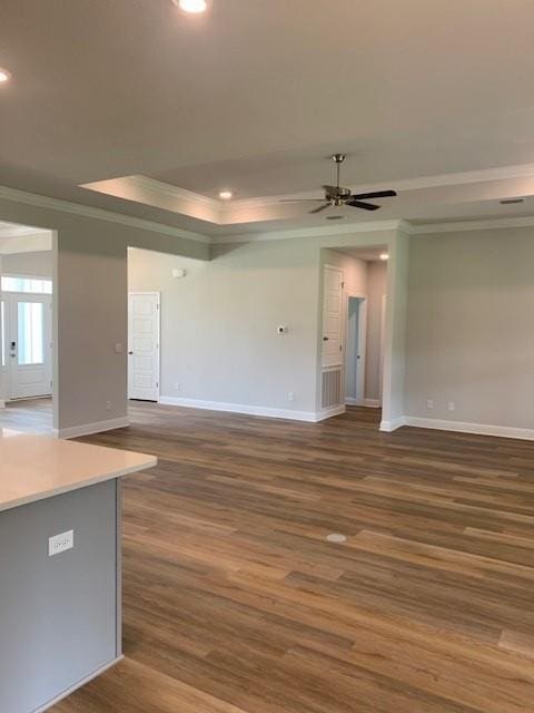 unfurnished living room with dark wood-type flooring, ornamental molding, and ceiling fan