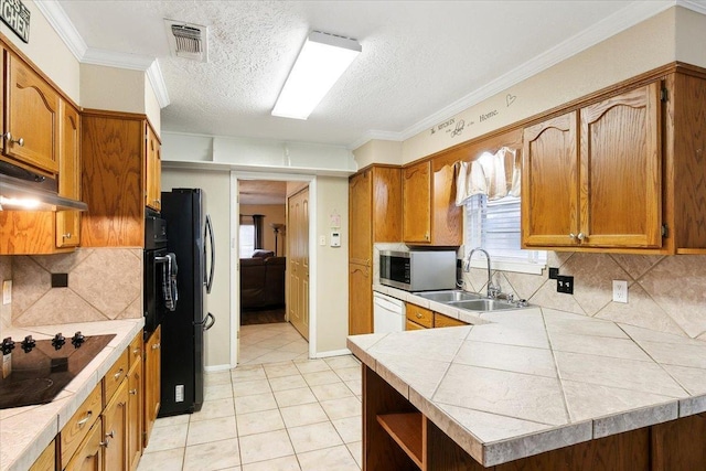 kitchen with decorative backsplash, sink, black appliances, and a textured ceiling