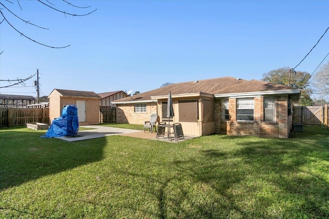 back of property featuring a lawn, a shed, and a patio