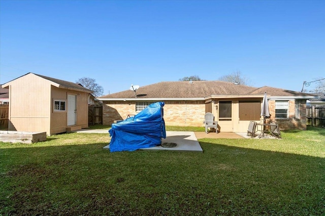 rear view of property with a storage unit and a yard