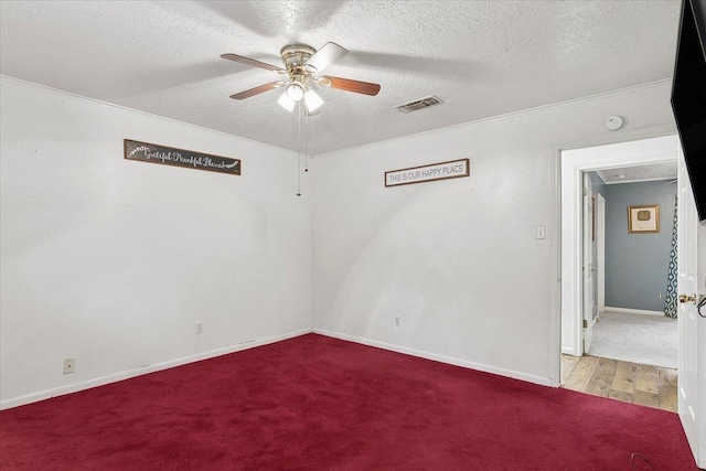 unfurnished room with ceiling fan, light carpet, and a textured ceiling