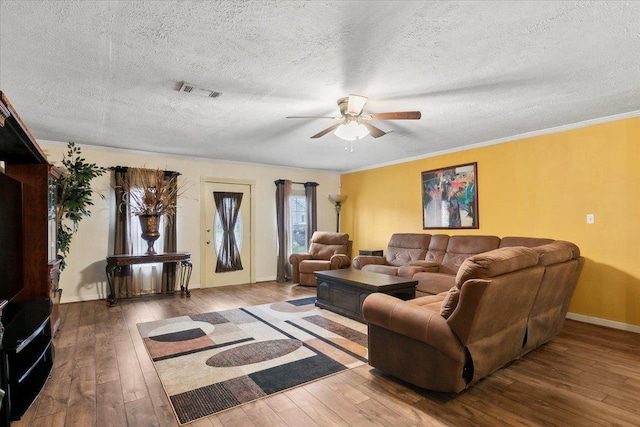 living room with hardwood / wood-style flooring, ceiling fan, crown molding, and a textured ceiling