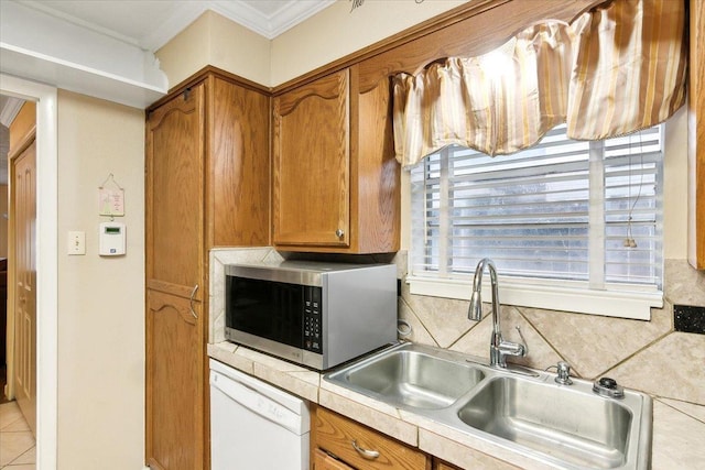 kitchen with sink, backsplash, white dishwasher, light tile patterned floors, and ornamental molding