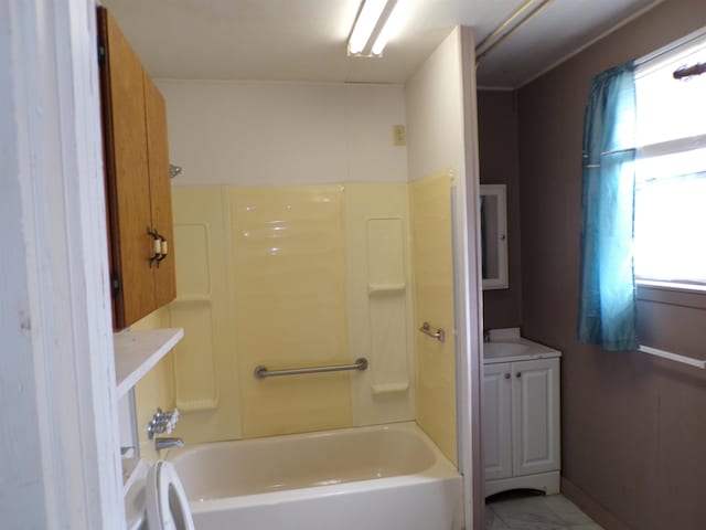 bathroom featuring tub / shower combination, vanity, and baseboards