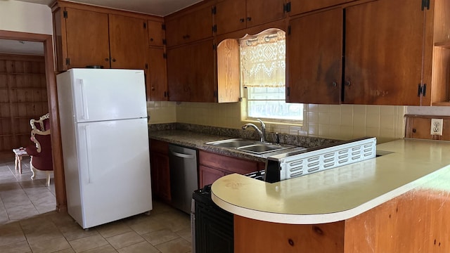4011 Everglades Ave, Port Arthur, TX 77642 - kitchen featuring freestanding refrigerator, stainless steel dishwasher, tasteful backsplash, and light tile patterned floors