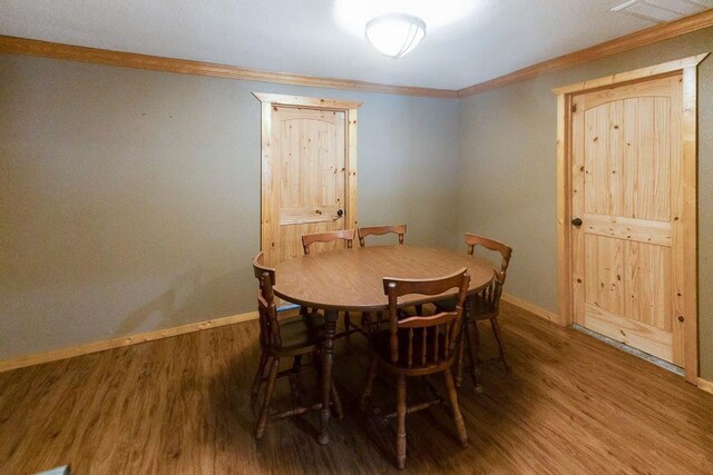 dining space with dark hardwood / wood-style floors and crown molding