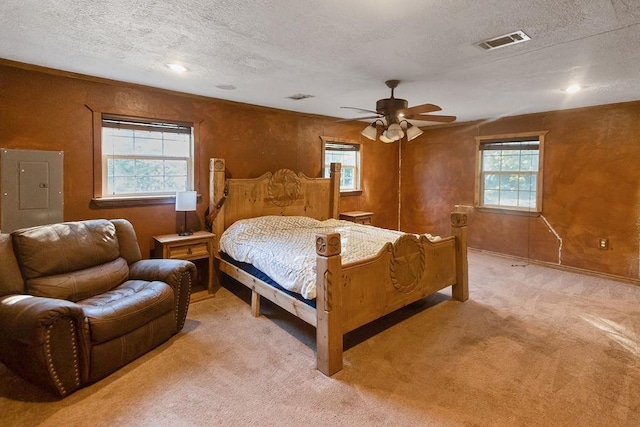 bedroom featuring multiple windows, a textured ceiling, electric panel, and ceiling fan