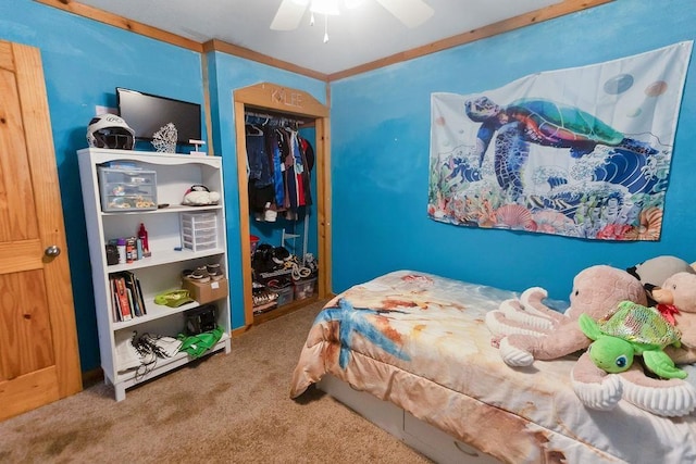 carpeted bedroom featuring a closet, ceiling fan, and ornamental molding