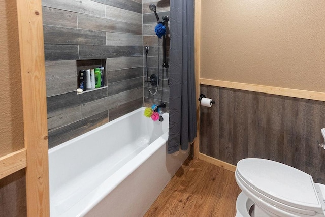 bathroom with hardwood / wood-style floors, shower / bath combo, and toilet