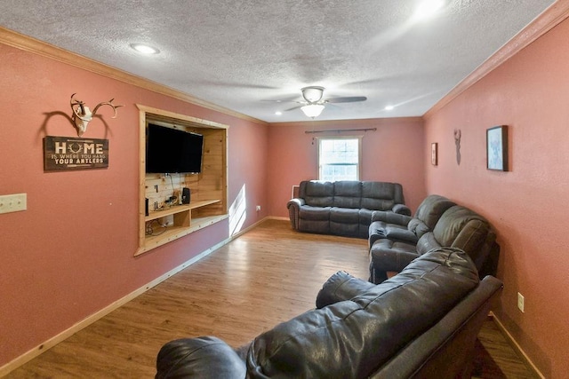 living room with a textured ceiling, light hardwood / wood-style flooring, ceiling fan, and crown molding