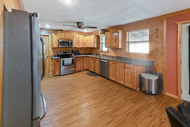 kitchen with sink, light hardwood / wood-style flooring, ceiling fan, a textured ceiling, and stainless steel appliances