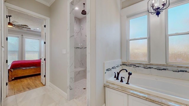 bathroom with ornamental molding, shower with separate bathtub, and ceiling fan with notable chandelier