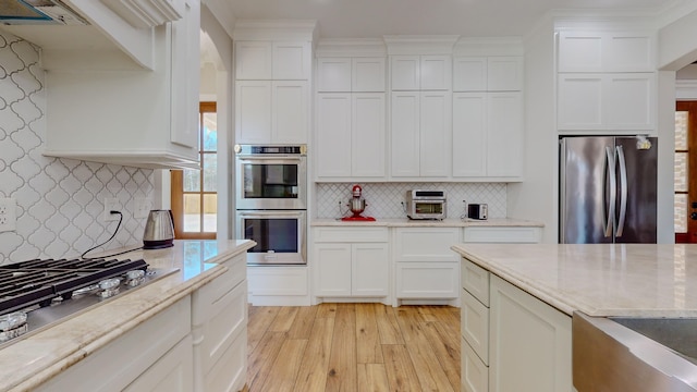 kitchen with backsplash, stainless steel appliances, and white cabinetry