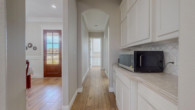 hallway featuring light wood-type flooring and crown molding